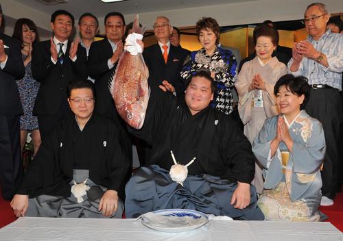 大関昇進を決めた照ノ富士は、お祝いのタイを手ににっこり。左は伊勢ケ浜親方、右は淳子夫人（2015年5月27日撮影）