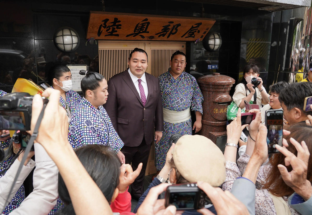 霧馬山の大関昇進伝達式を終えた鶴竜親方（中央）は部屋の前で写真撮影のファンサービス（撮影・小沢裕）