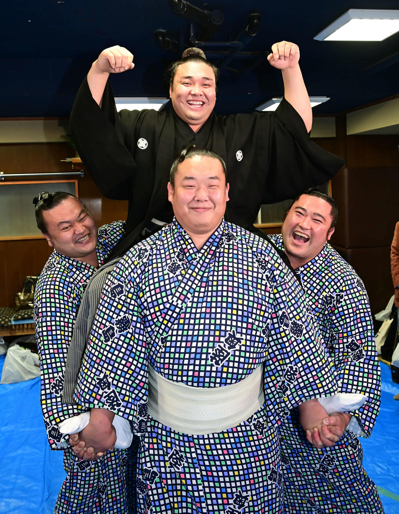 大関昇進伝達式を終えた霧馬山（上）は若い衆の騎馬の上でガッツポーズ。左から勇輝、神谷、大日堂（撮影・小沢裕）