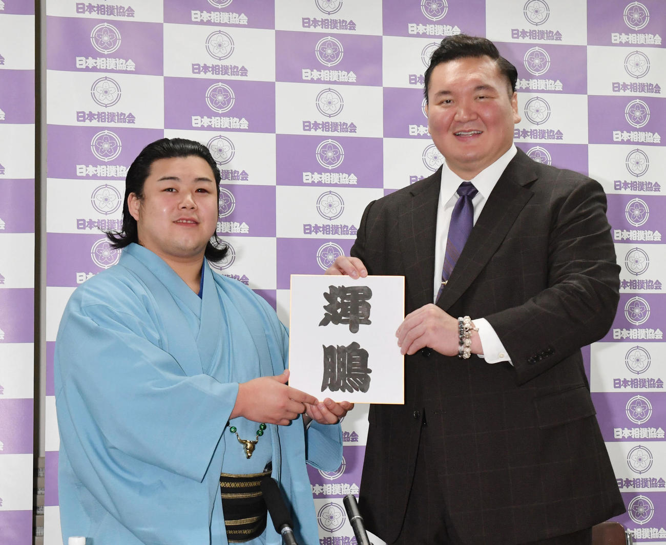 新十両昇進会見に臨んだ川副（左）は「輝鵬」と改名を発表し師匠の宮城野親方（元横綱白鵬）と新しいしこ名の入った色紙を披露する