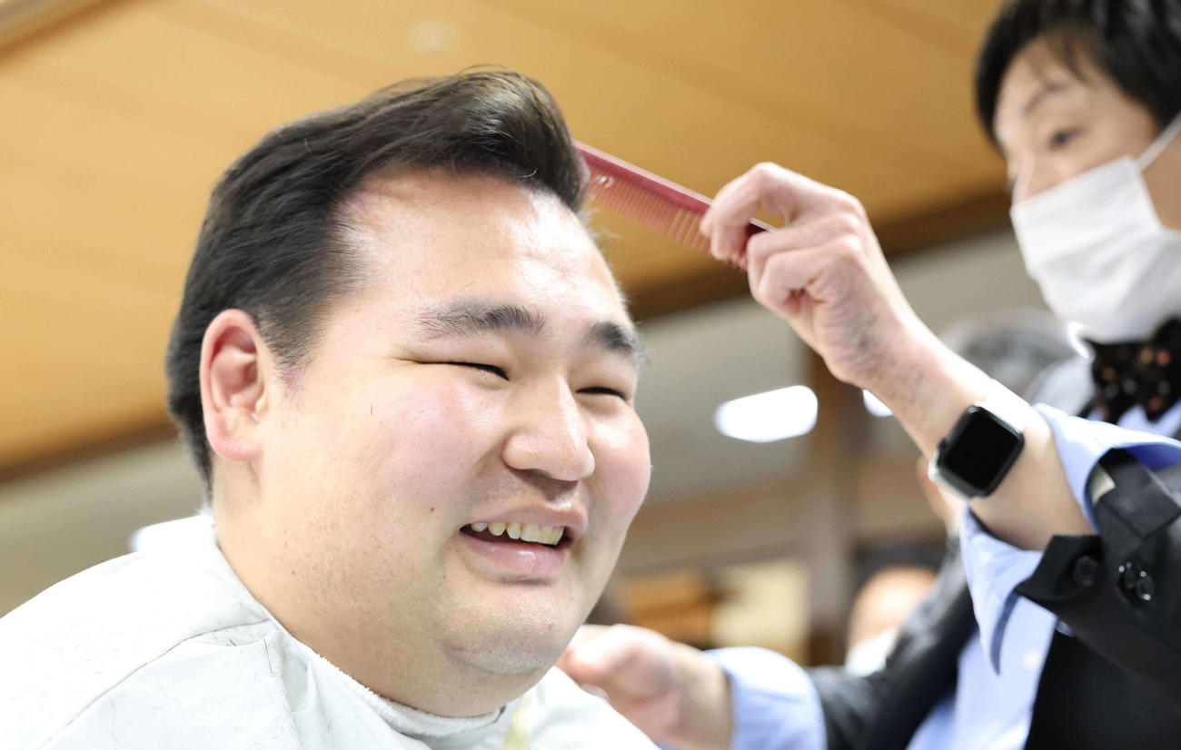 笑顔で整髪する鶴竜（代表撮影）