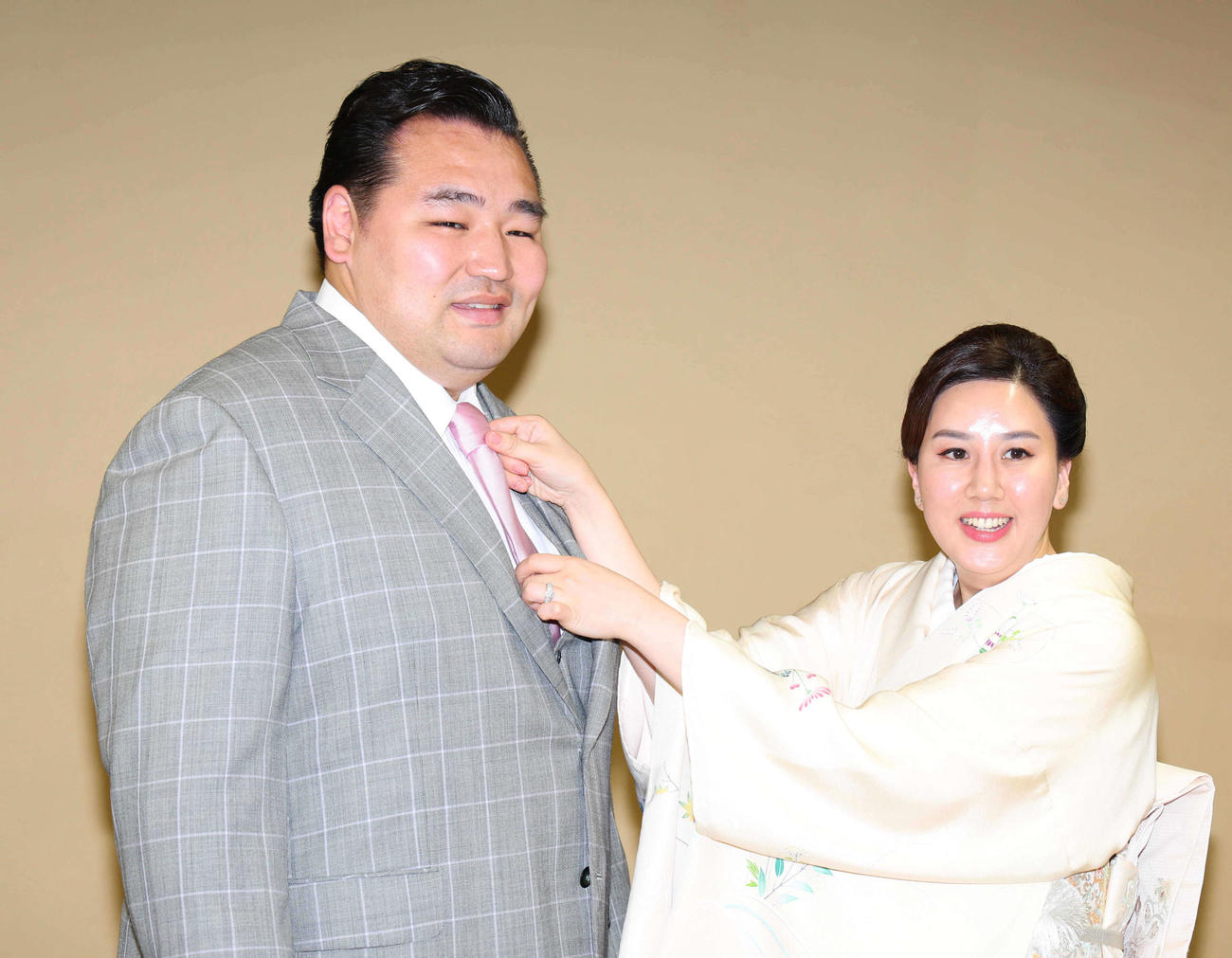 整髪を終え、ダシニャム・ムンフザヤ夫人（右）にネクタイを整えてもらう鶴竜（代表撮影）