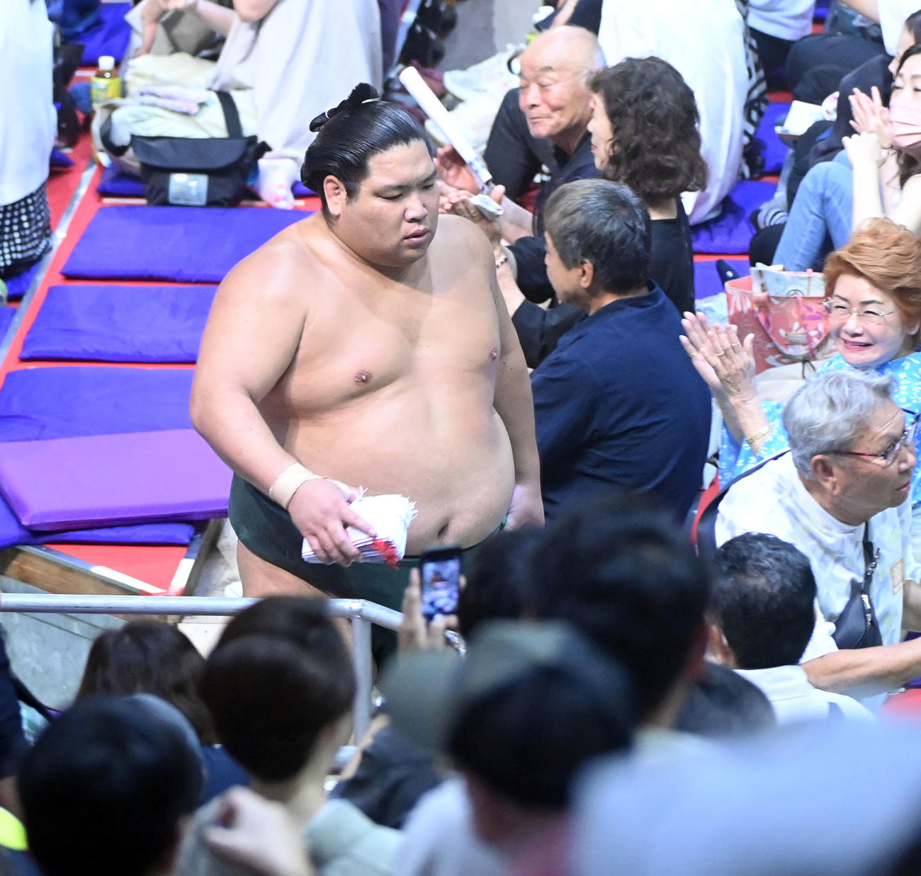 照ノ富士をすくい投げで破り懸賞を手に花道を引き揚げる錦木（撮影・森本幸一）