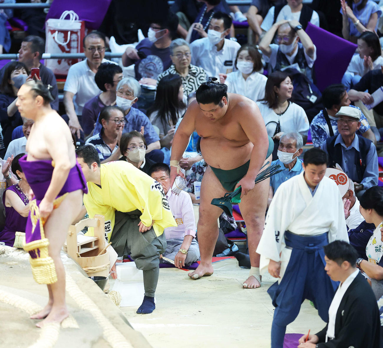 照ノ富士をすくい投げで破り、懸賞金の束を手に土俵から引き揚げる錦木（撮影・河田真司）