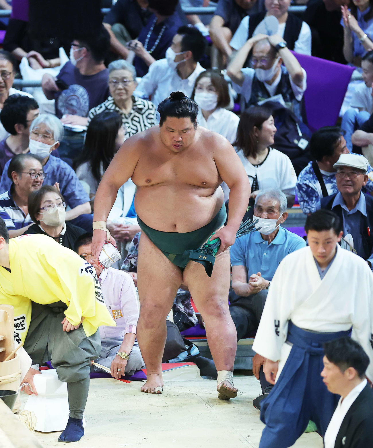 照ノ富士をすくい投げで破り、懸賞金の束を手に土俵から引き揚げる錦木（撮影・河田真司）