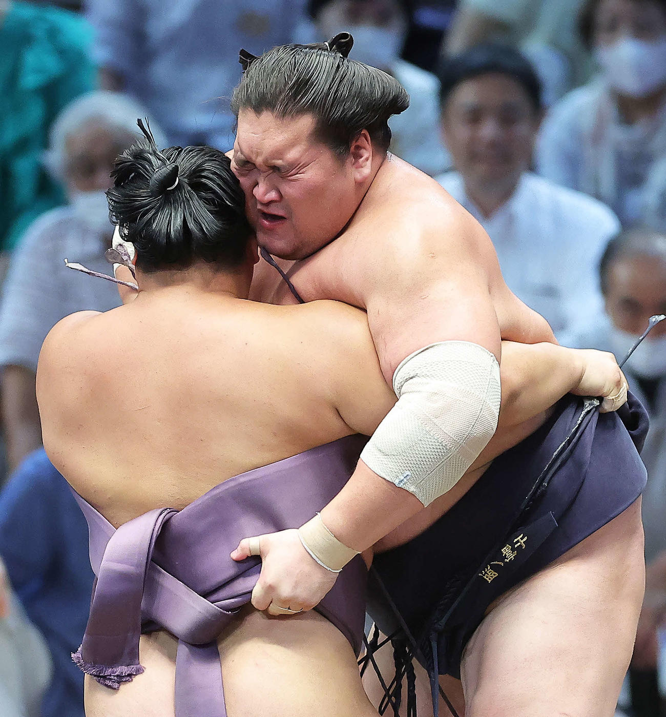 翔猿（手前）との激しいぶつかり合いに険しい表情を見せる照ノ富士（撮影・河田真司）