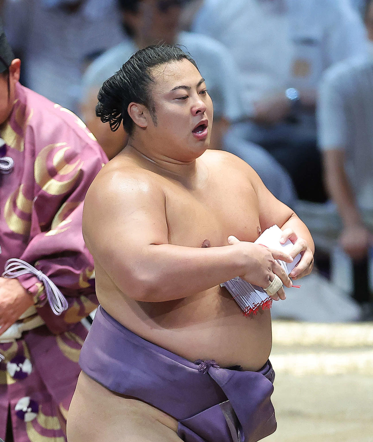 照ノ富士を寄り切りで破り、懸賞金の束を手に土俵から引き揚げる翔猿（撮影・河田真司）