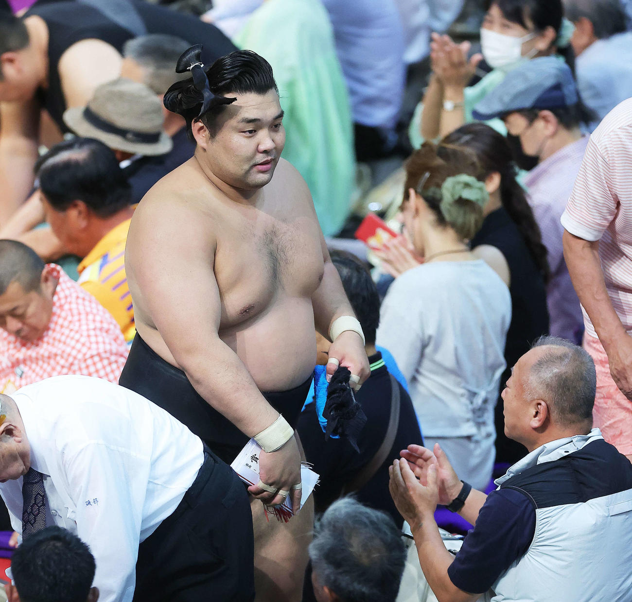 琴ノ若を送り出しで破り、懸賞金の束を手に土俵から引き揚げる霧島（撮影・河田真司）