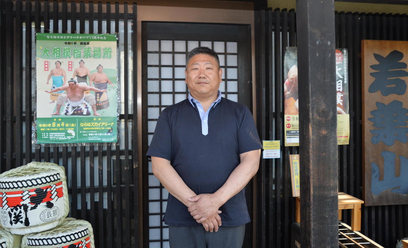 若隆元、若元春、若隆景ら、3兄弟の父・政志さんが、自身が店主を務める「ちゃんこ若葉山」の前で写真撮影（撮影・濱本神威）