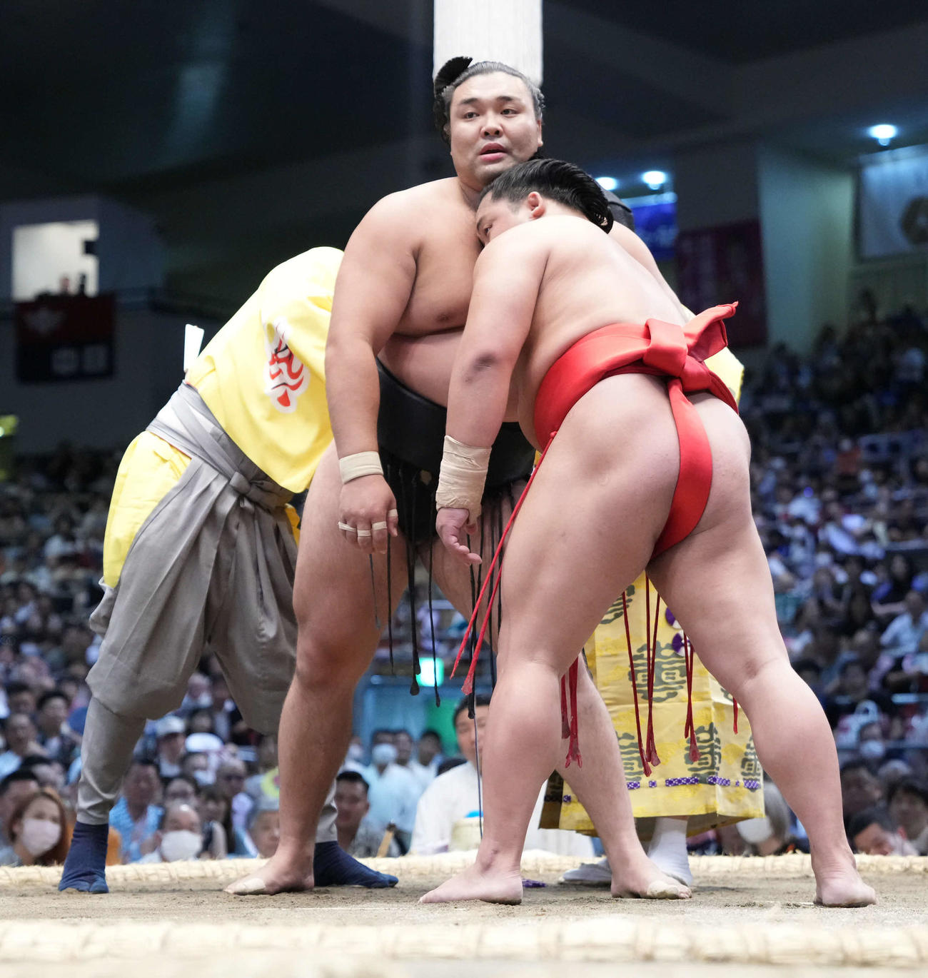 霧島と翠富士（右）の一番で「まわし待った」が掛かり呼び出しの耕平（左）と2人掛かりで霧島のまわしを締める行司の式守伊之助（右奥）（撮影・小沢裕）