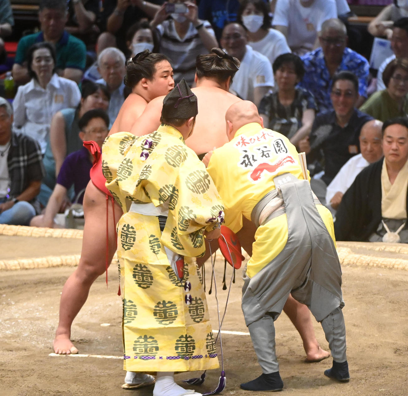 霧島のまわしが緩み二人がかりで締め直す（撮影・森本幸一）