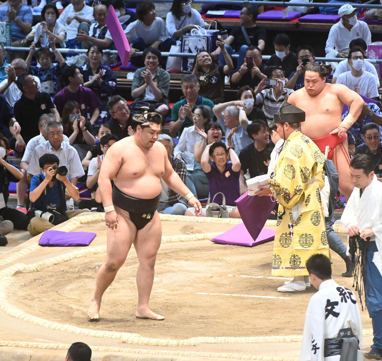 翠富士に下手投げで破れ座布団の舞う中引き上げる霧島（左）（撮影・森本幸一）