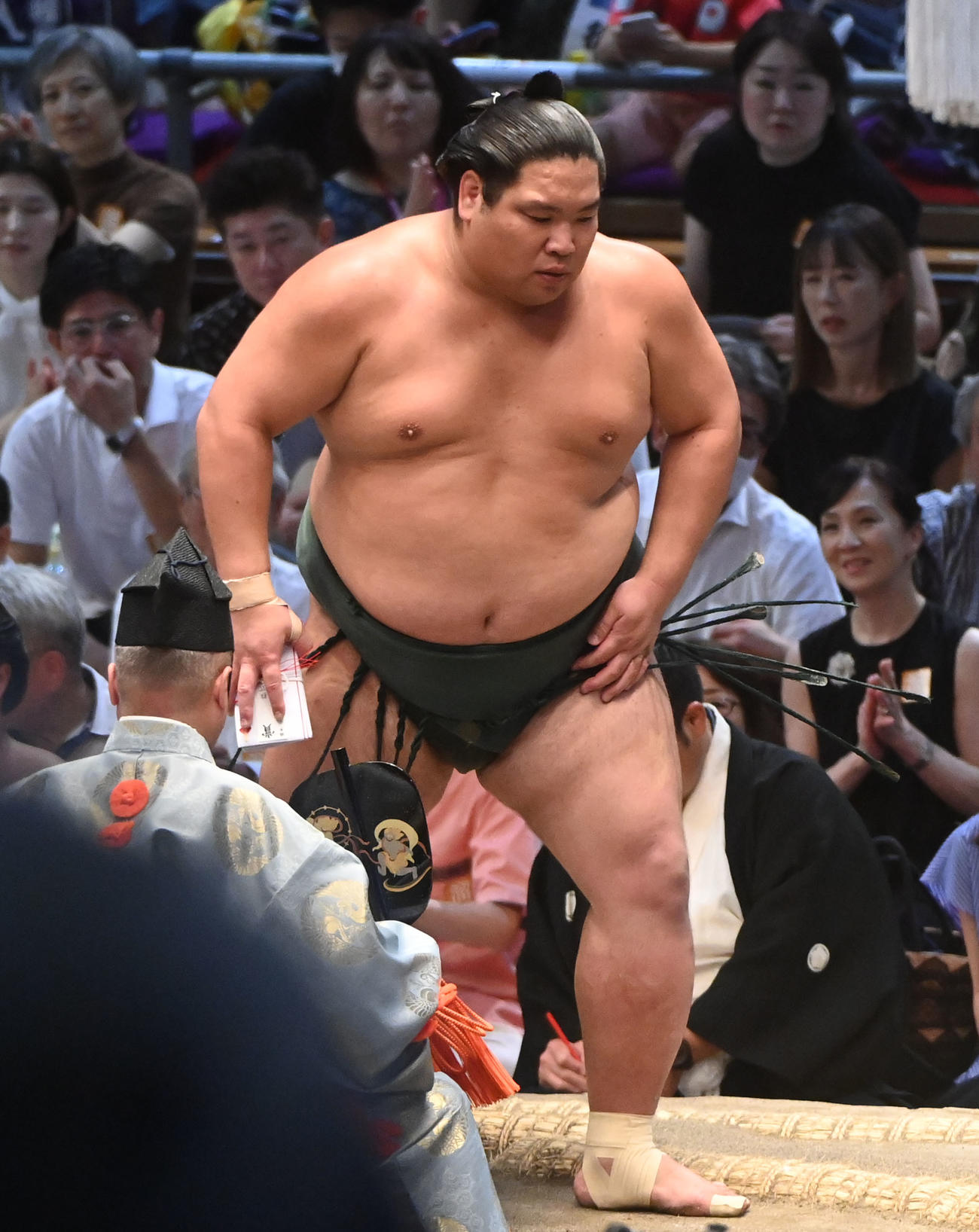 御嶽海を寄り切りで破り勝ち名乗りを受け懸賞を受け取る錦木（撮影・森本幸一）
