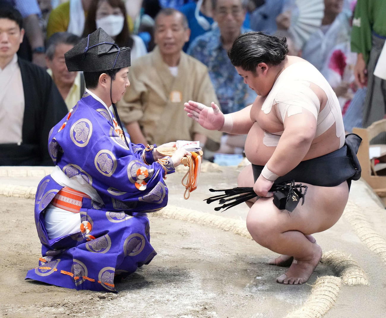 3敗目を死守した伯桜鵬は手刀を切って懸賞金を受け取る（撮影・小沢裕）