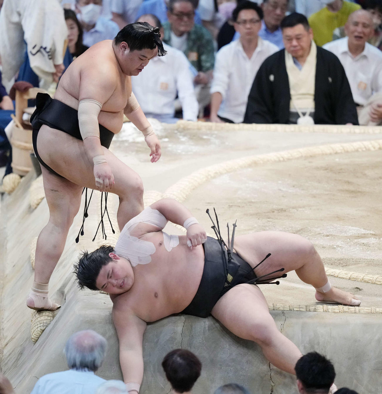取組後に左肩を痛め苦悶の表情で土俵下に降りる伯桜鵬。左は心配そうに見つめる阿炎（撮影・小沢裕）