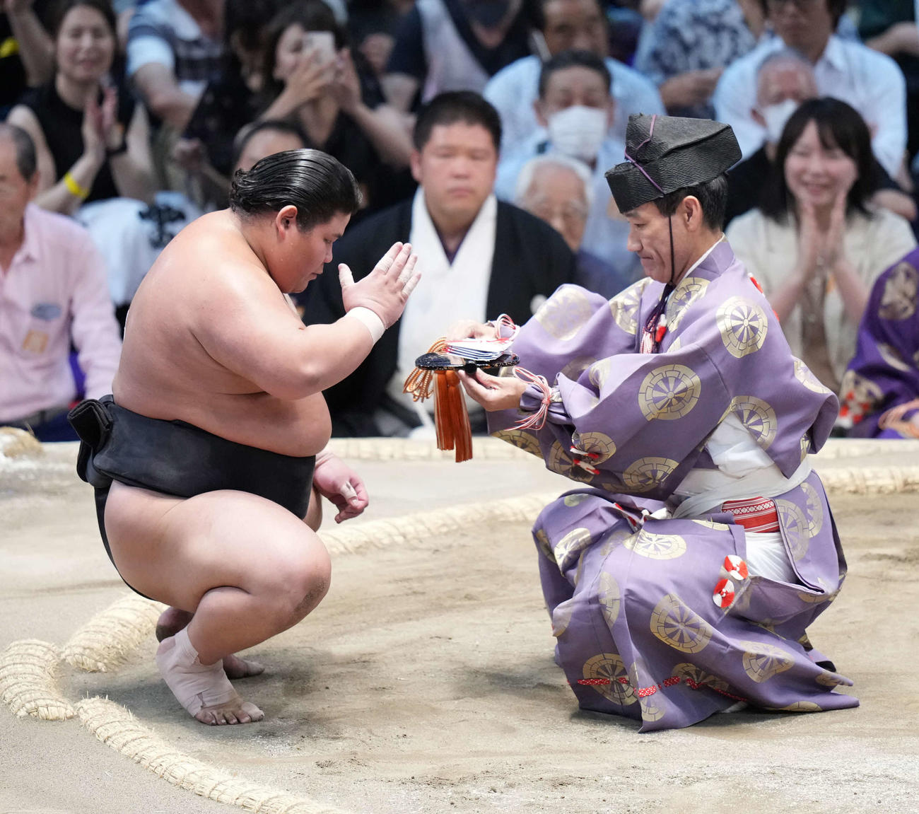手刀を切り懸賞金を手にする伯桜鵬（撮影・小沢裕）