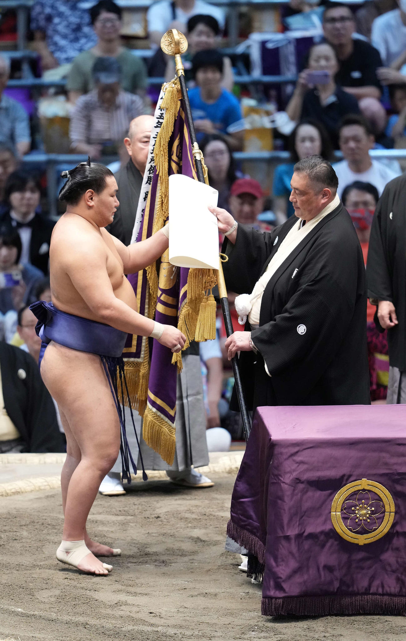 佐渡ケ嶽審判部長（右）から優勝旗の贈呈を受ける豊昇龍（撮影・小沢裕）