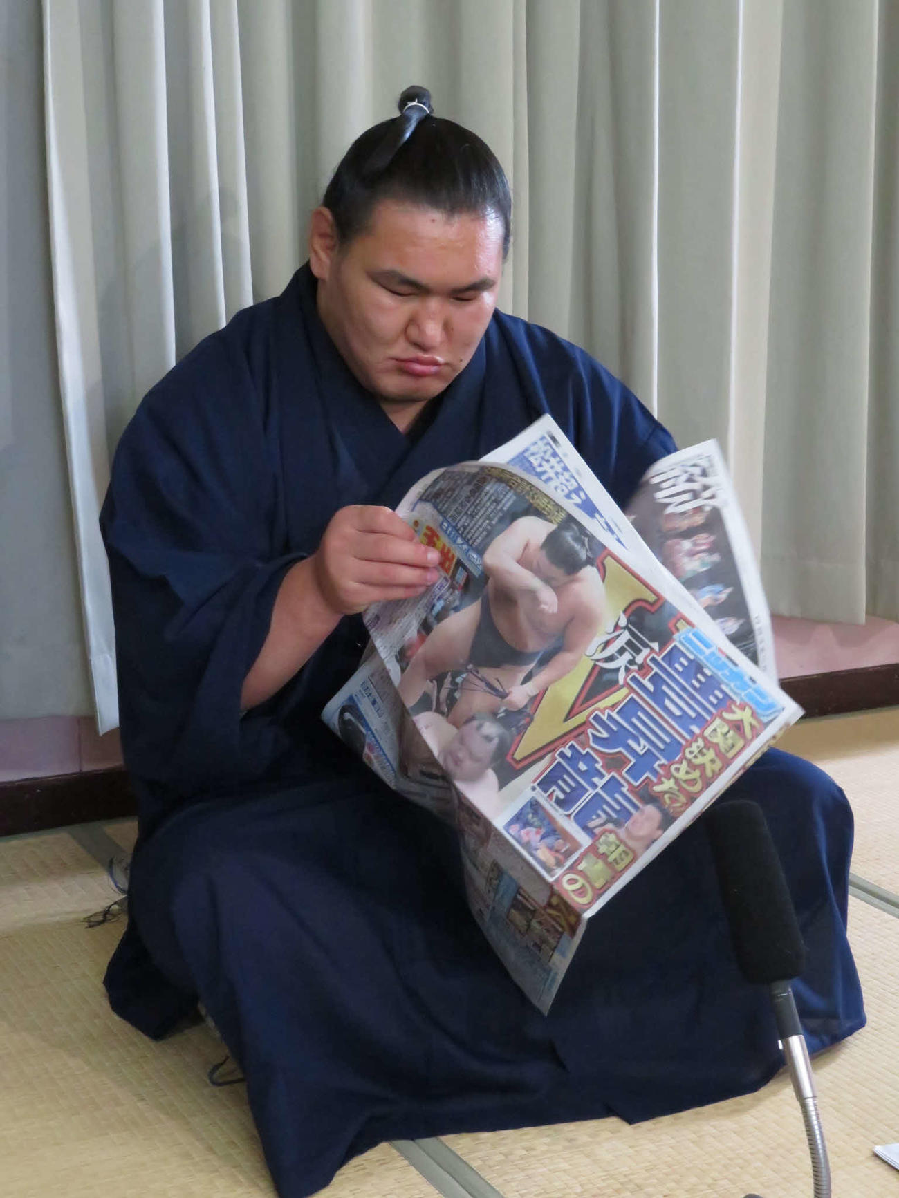 一夜明け会見後、24日付の本紙を読み込む豊昇龍