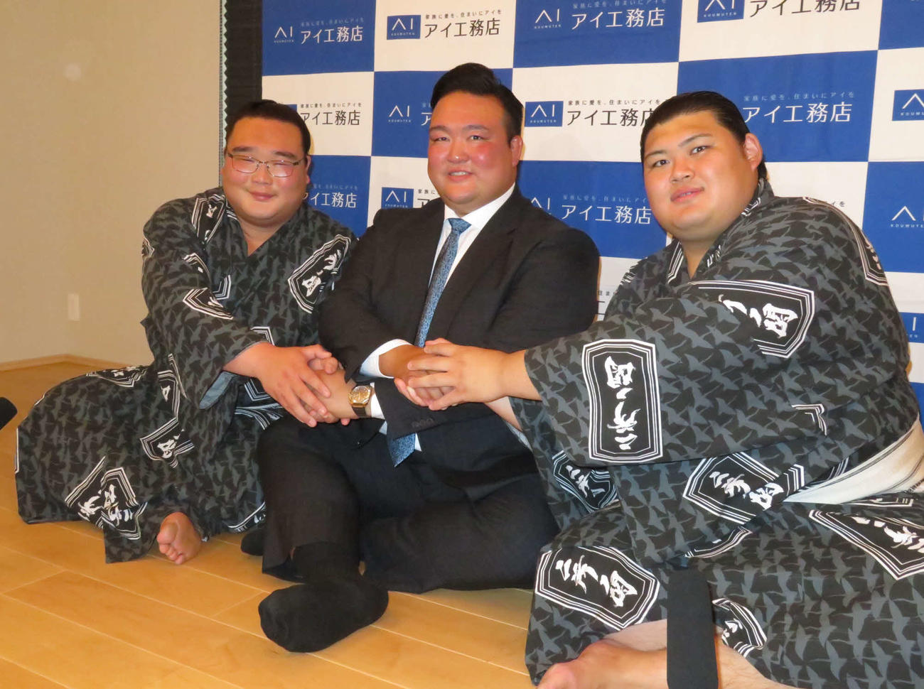 新十両に昇進し、師匠の二所ノ関親方（中央）と握手を交わす高橋（左）と大の里