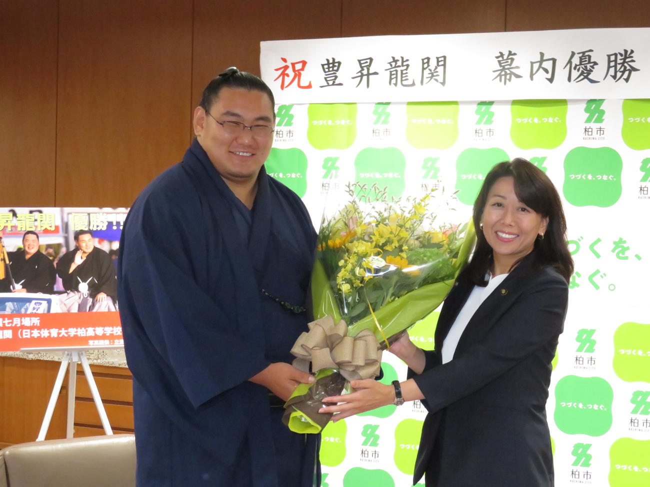 千葉・柏市役所を表敬訪問し、太田和美市長（右）から花束を贈呈され笑顔を見せる豊昇龍