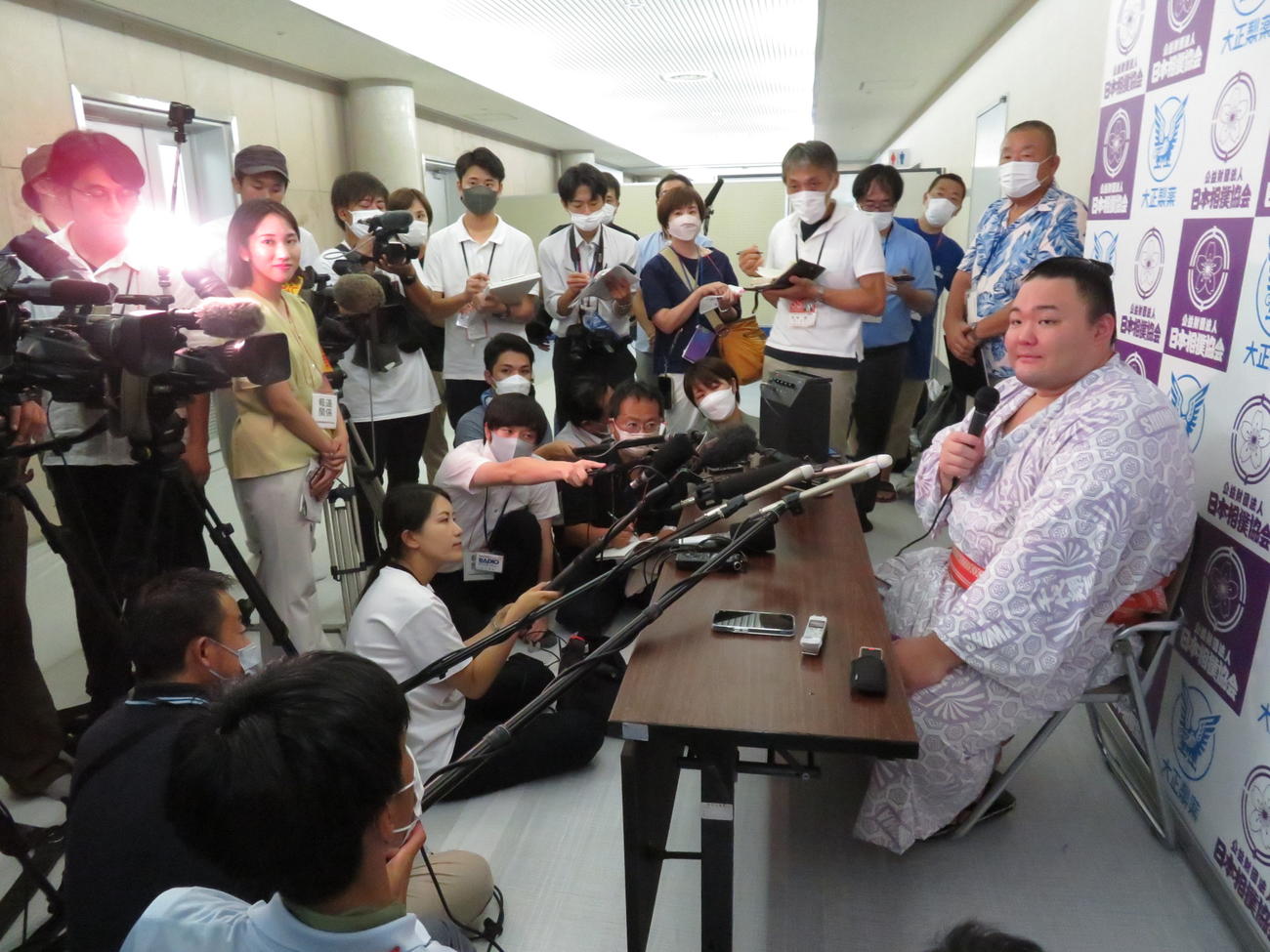 地元テレビ局など大勢の報道陣の取材に応じる朝乃山（右端）