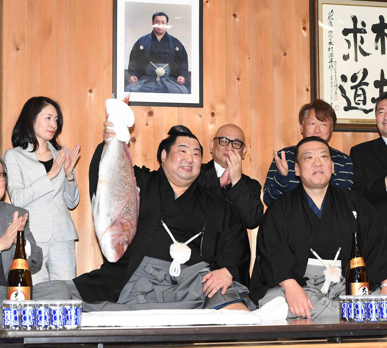 木瀬部屋での祝勝会で鯛を持つ徳勝龍。右は師匠の木瀬親方（2020年1月26日撮影）