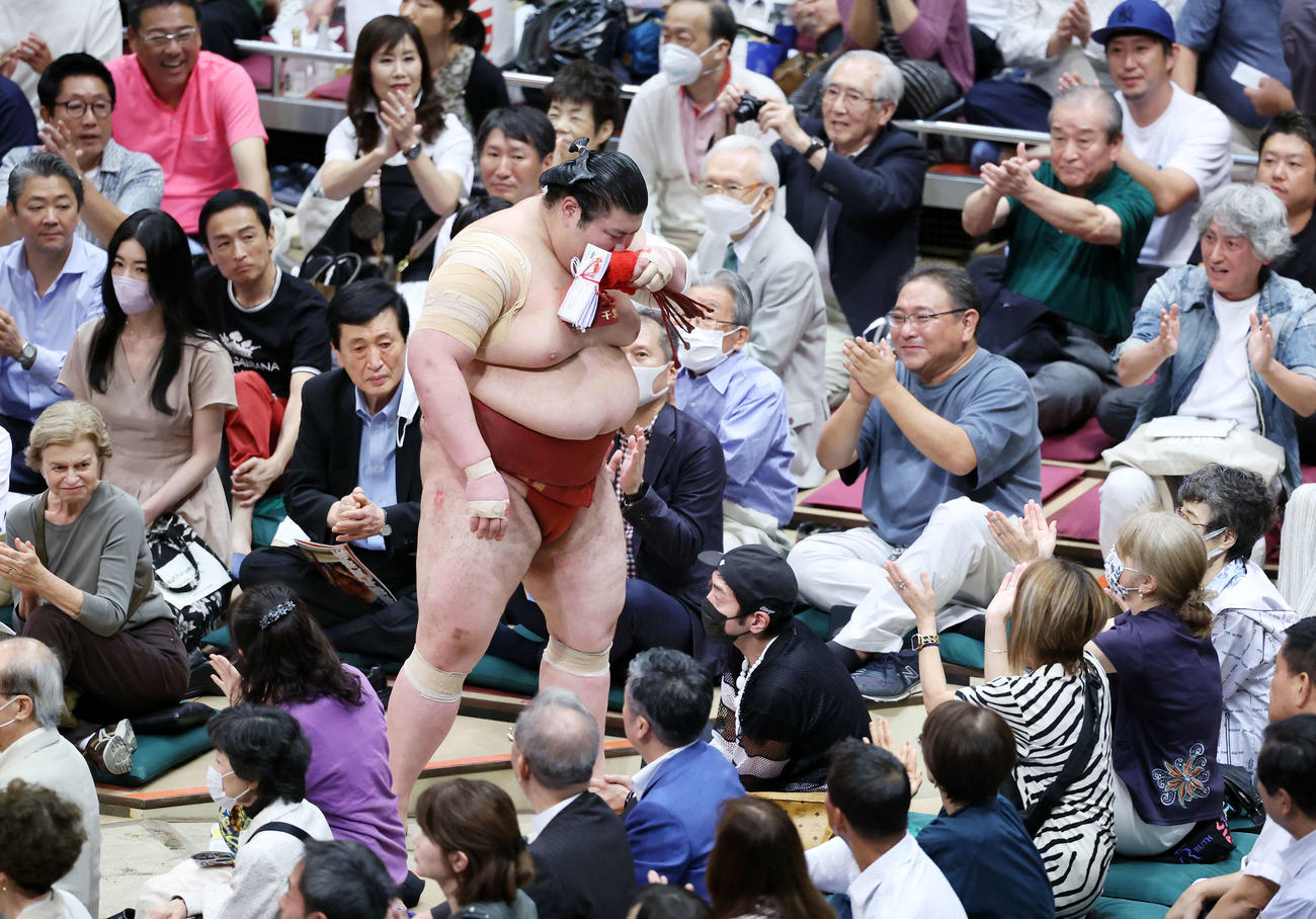 観客の拍手で土俵を引き揚げる熱海富士（撮影・鈴木正人）
