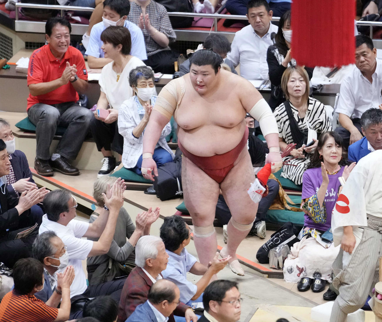 3敗を死守した熱海富士は鼻血止めのティッシュをしながら花道を引き揚げる（撮影・小沢裕）
