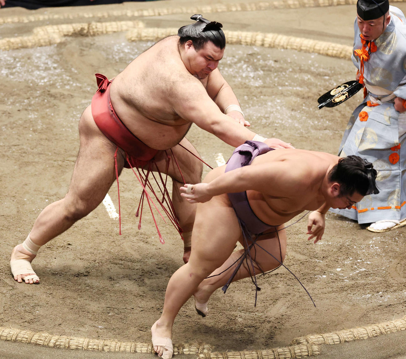 翔猿（右）を送り出しで破る高安（撮影・野上伸悟）