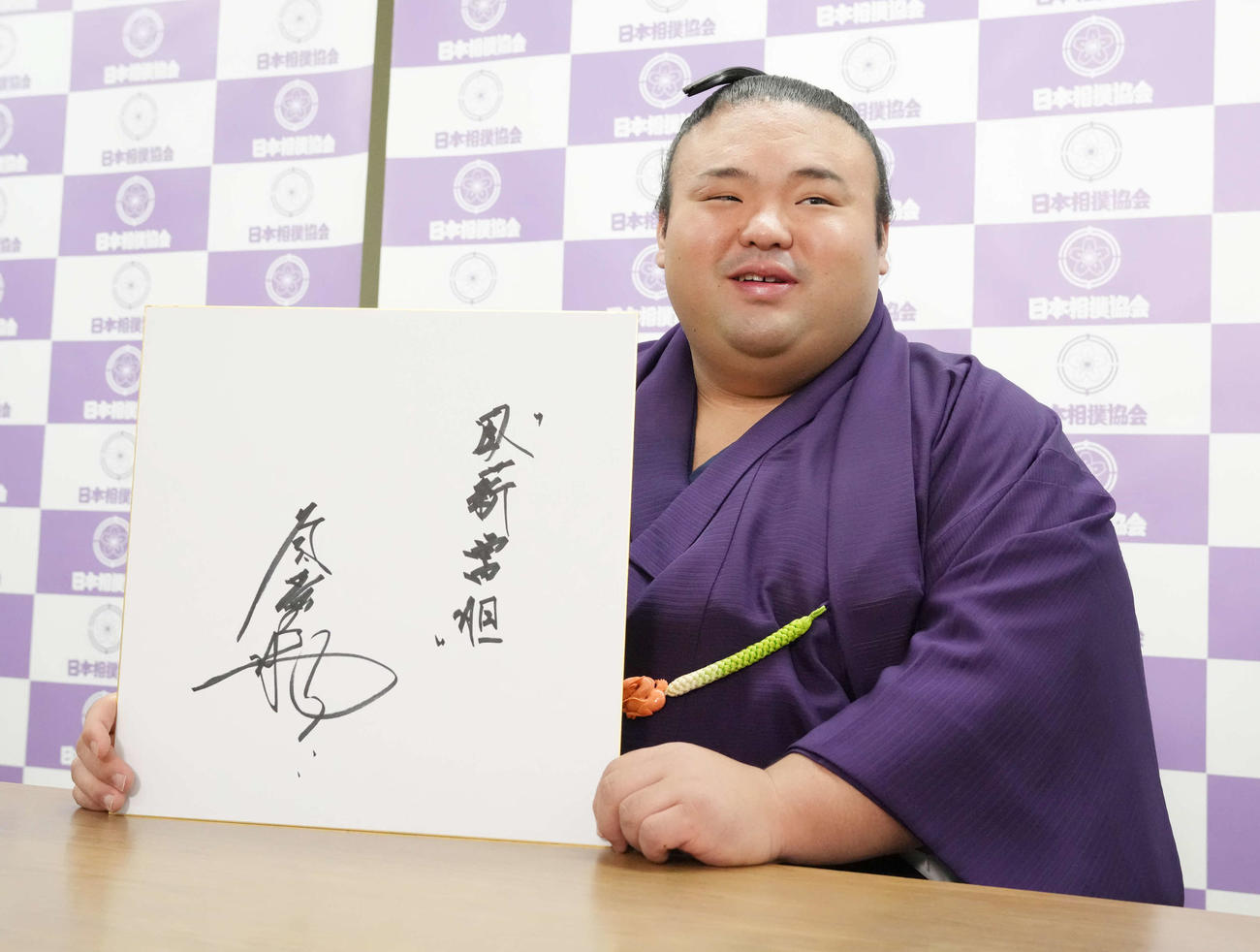 優勝一夜明け会見で色紙に好きな言葉として「臥薪嘗胆（がしんしょうたん）」としたため笑顔を見せる貴景勝（撮影・小沢裕）