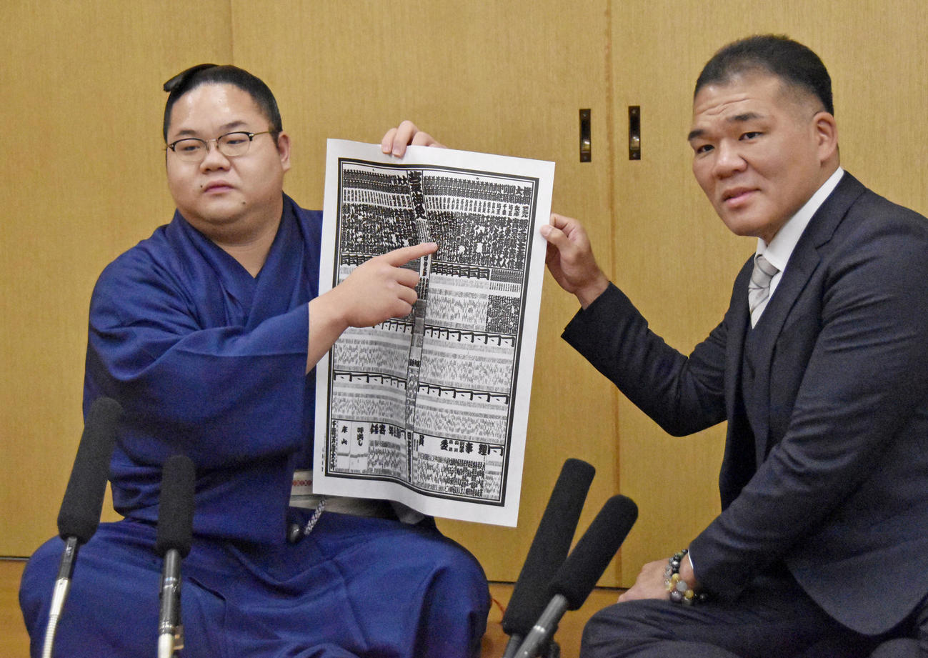 大相撲九州場所の番付表を手にする新入幕の東白龍（左）と玉ノ井親方（共同）