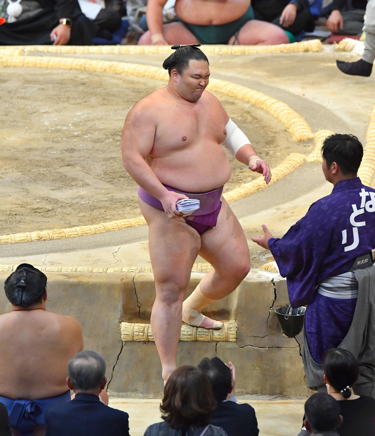 下手投げで貴景勝を破り、懸賞の束を手に土俵を下りる朝乃山（撮影・岩下翔太）