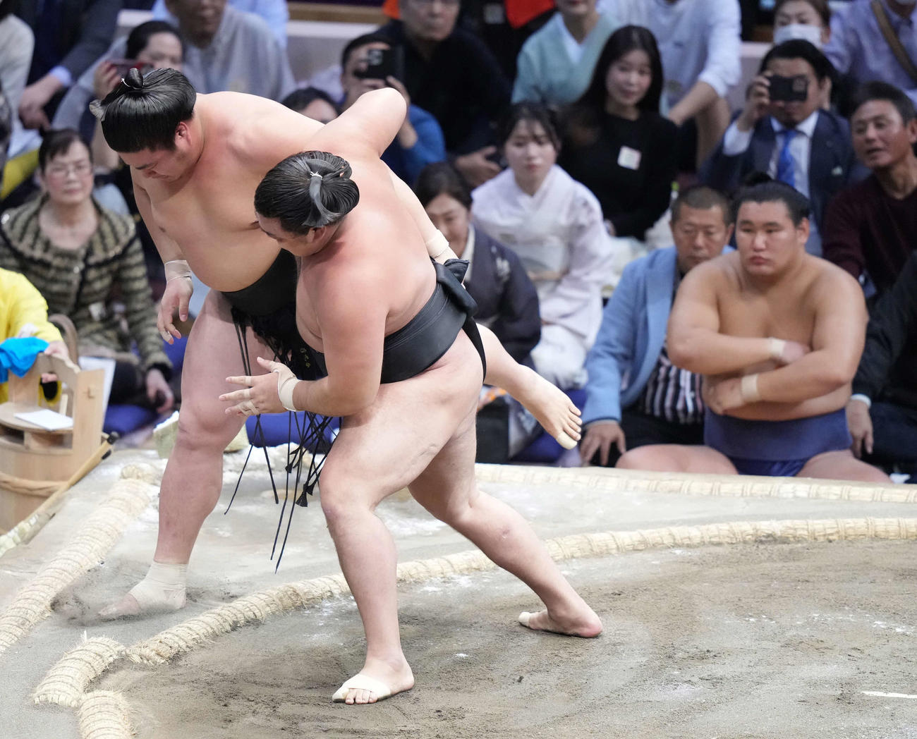 霧島は若元春（左）を寄り切りで破る。右は土俵下控えの豊昇龍（撮影・小沢裕）