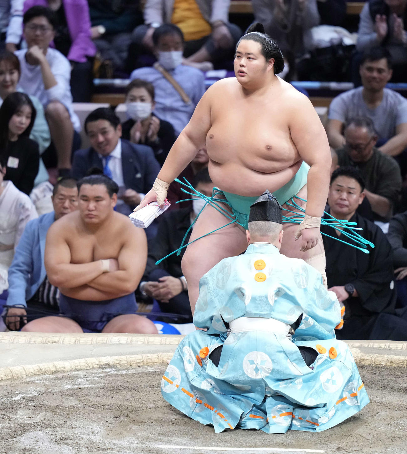 懸賞を手にする琴ノ若。左は土俵下控えの豊昇龍（撮影・小沢裕）