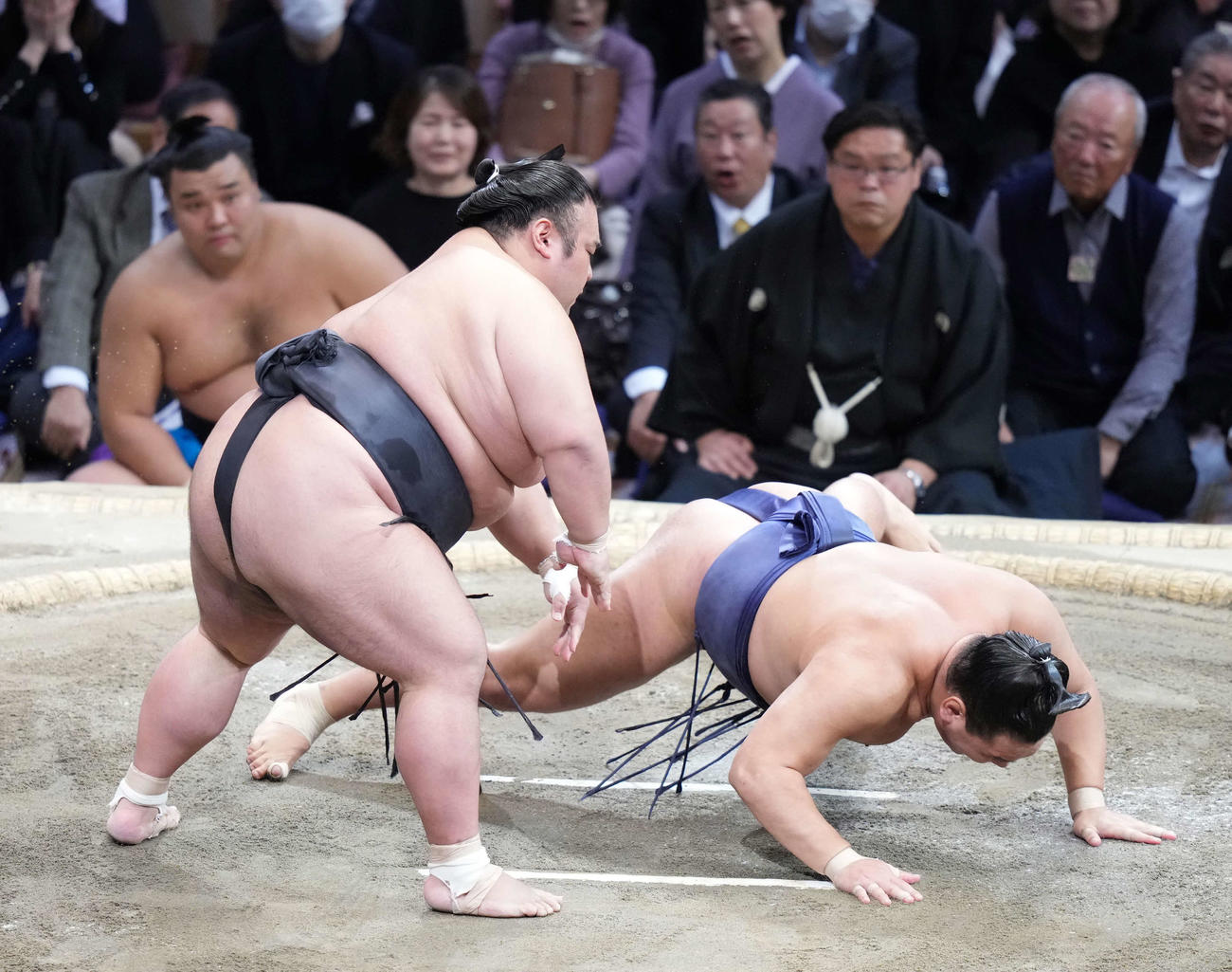 貴景勝は豊昇龍（右）を突き落としで破る。左奥は土俵下控えの霧島（撮影・小沢裕）