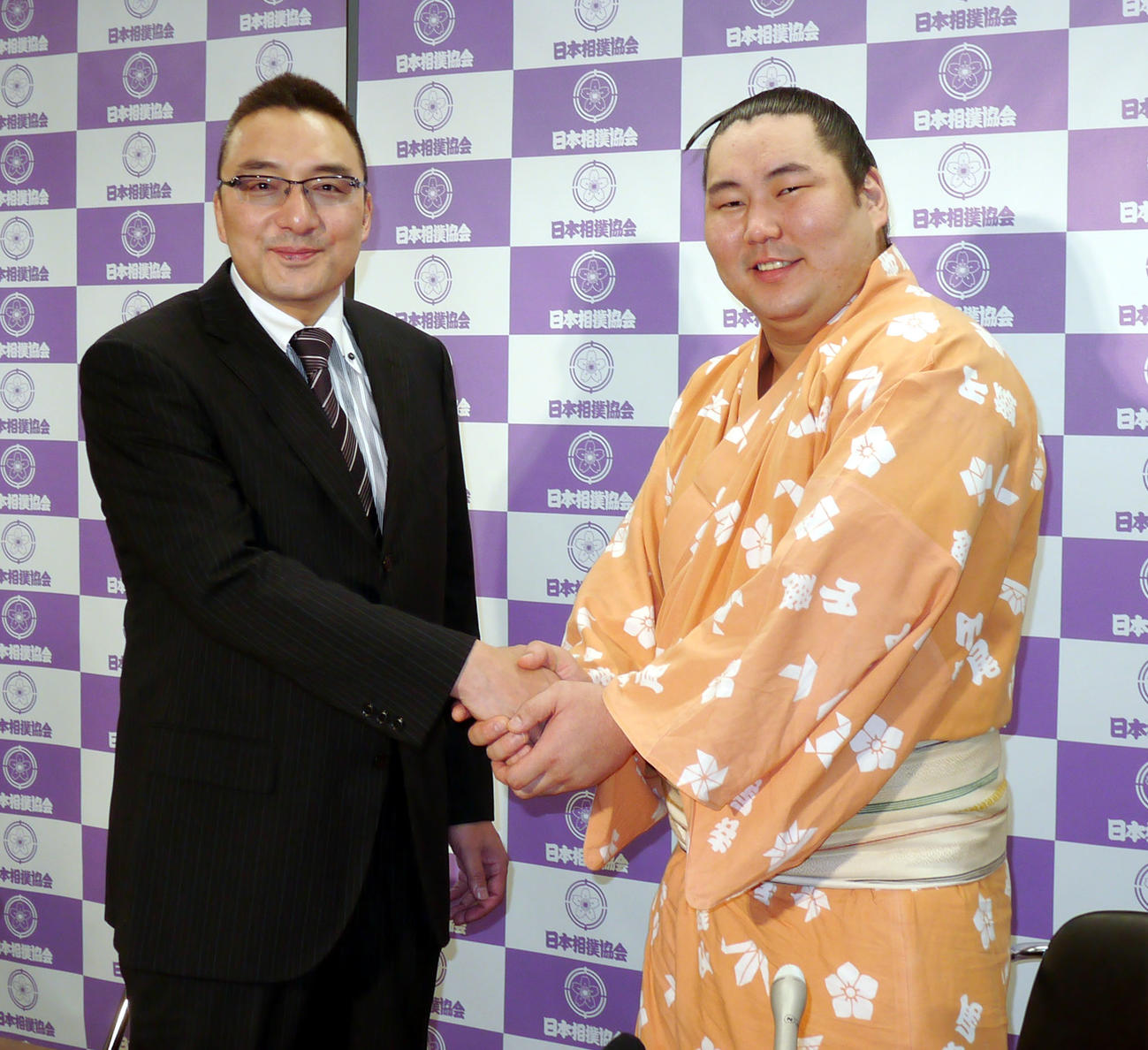 新十両昇進を決めて、師匠の錣山親方（左＝元関脇寺尾）と握手する青狼（2013年5月撮影）