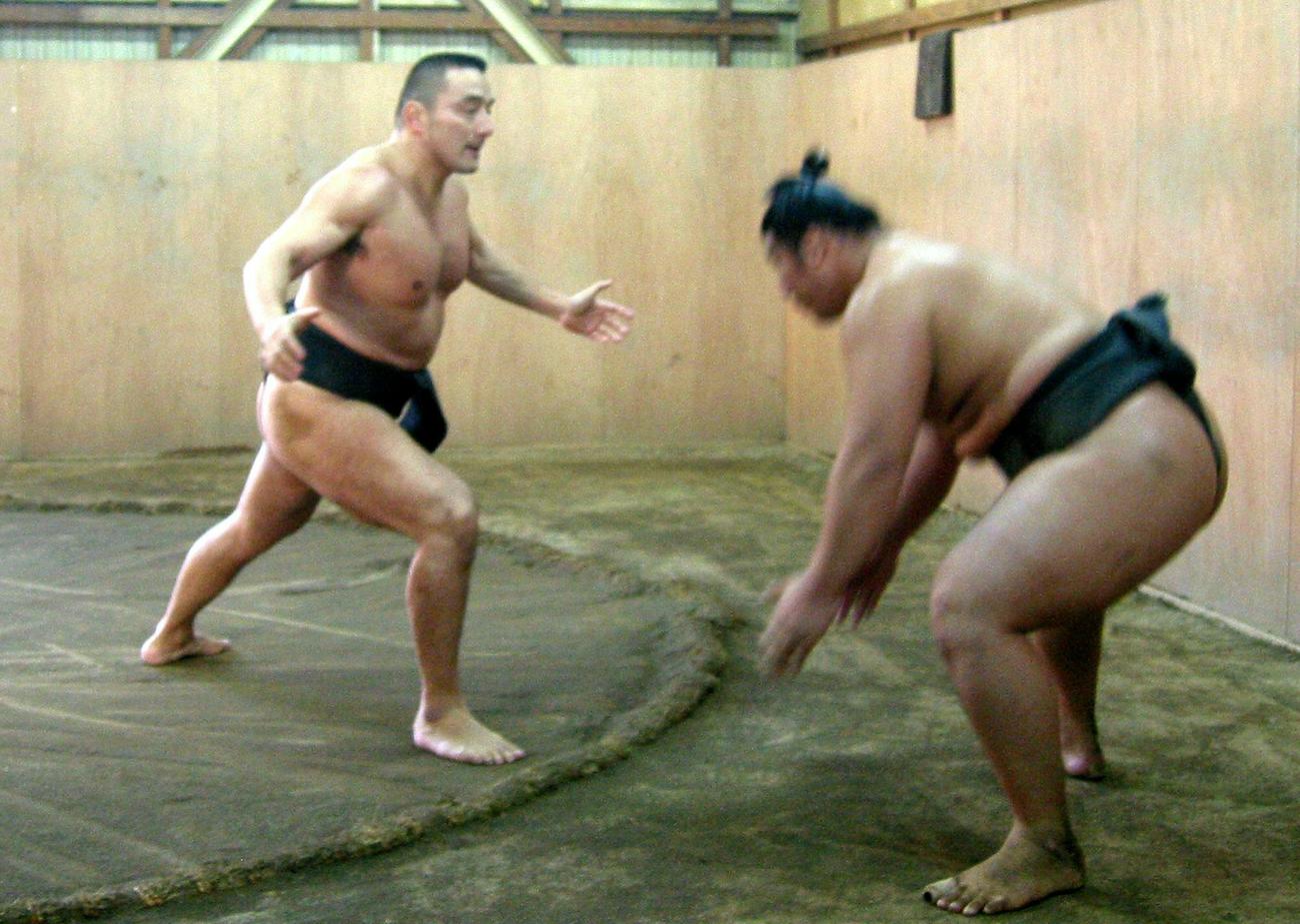 元関脇寺尾の錣山親方（左）は、まわしをつけて豊真将に胸を出す（05年9月撮影）
