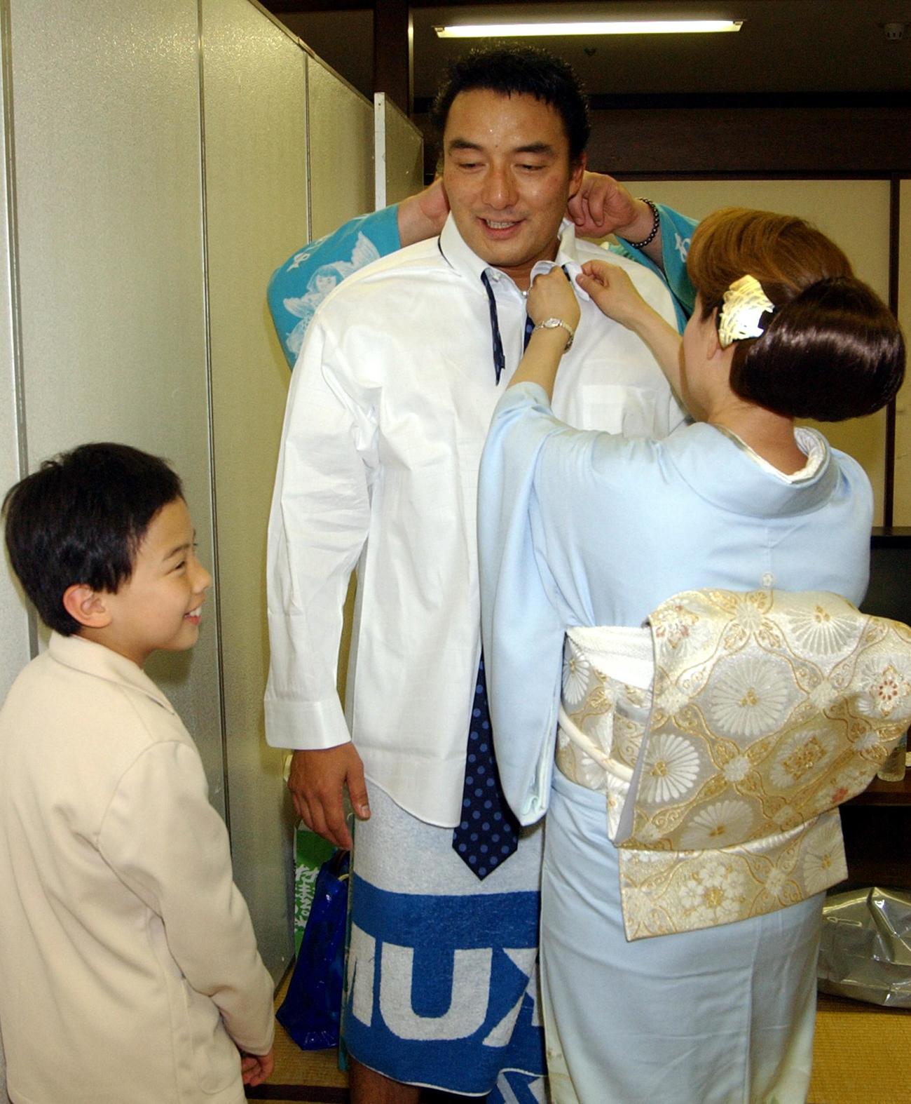 断髪式を終えた寺尾は、息子の晴也君が見守る中、伊津美夫人にネクタイを締めてもらう（2003年5月撮影）