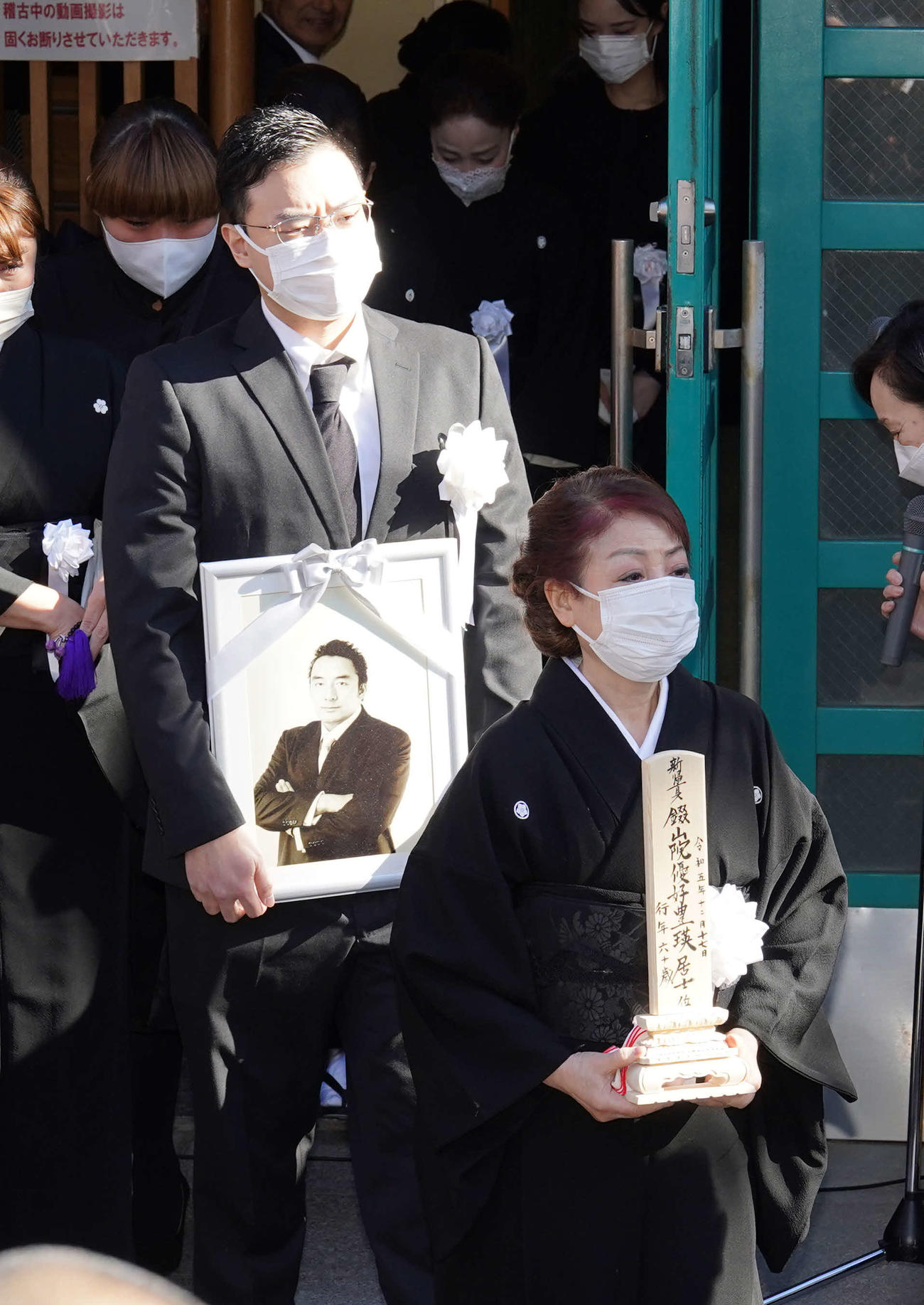 錣山親方の葬儀で位牌を手にする喪主の福薗伊津美さん（右）と遺影を持つ長男の晴也さん（撮影・小沢裕）