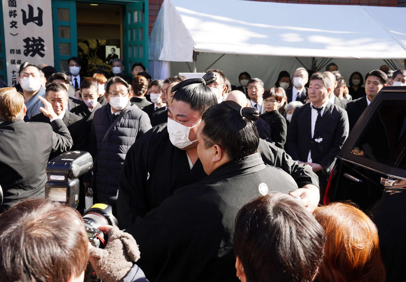 錣山親方の葬儀で納棺を終え阿武咲と抱擁を交わす阿炎（撮影・小沢裕）