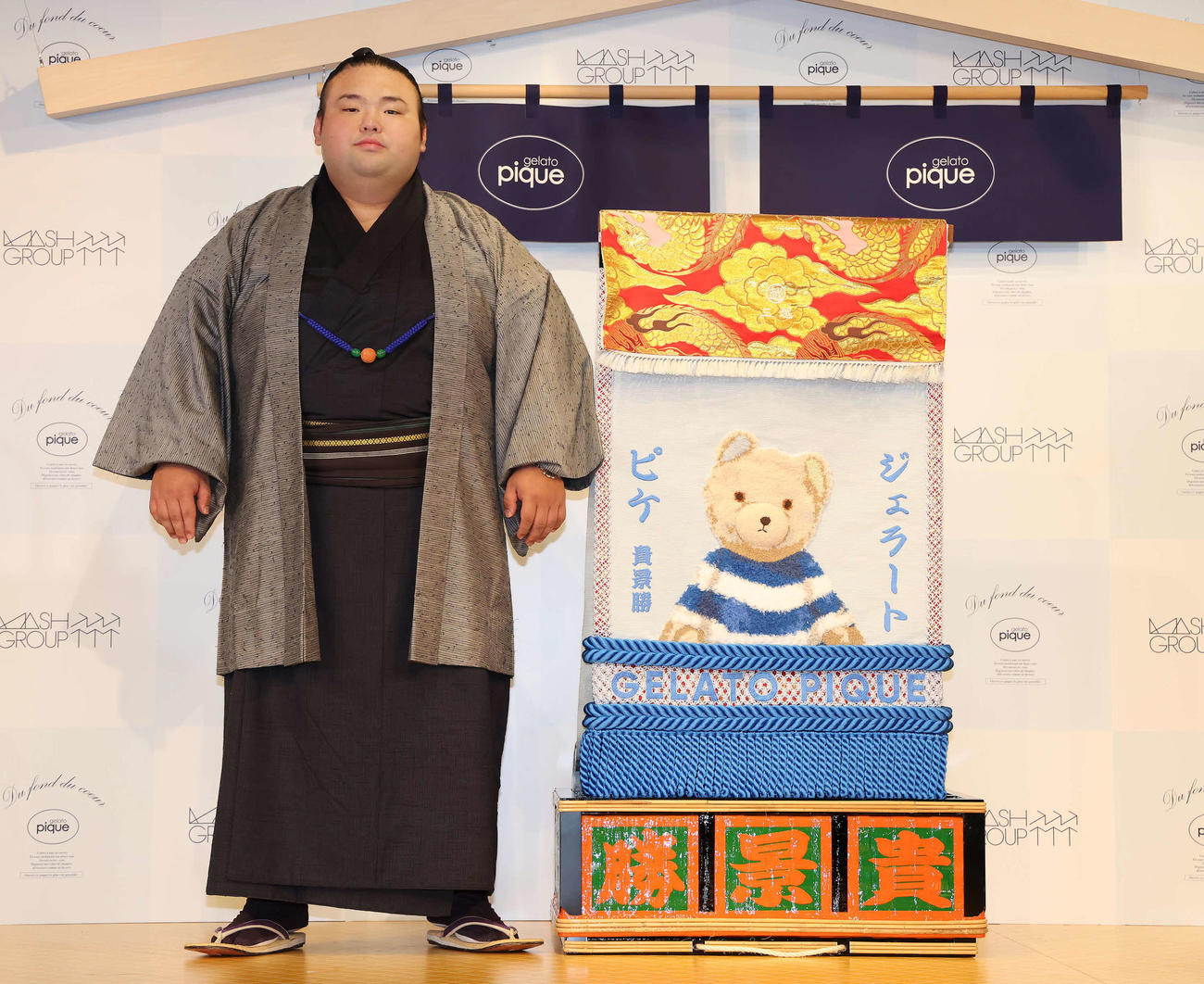 「ジェラート・ピケ」から贈呈された化粧まわしと写真に納まる貴景勝関（撮影・丹羽敏通）