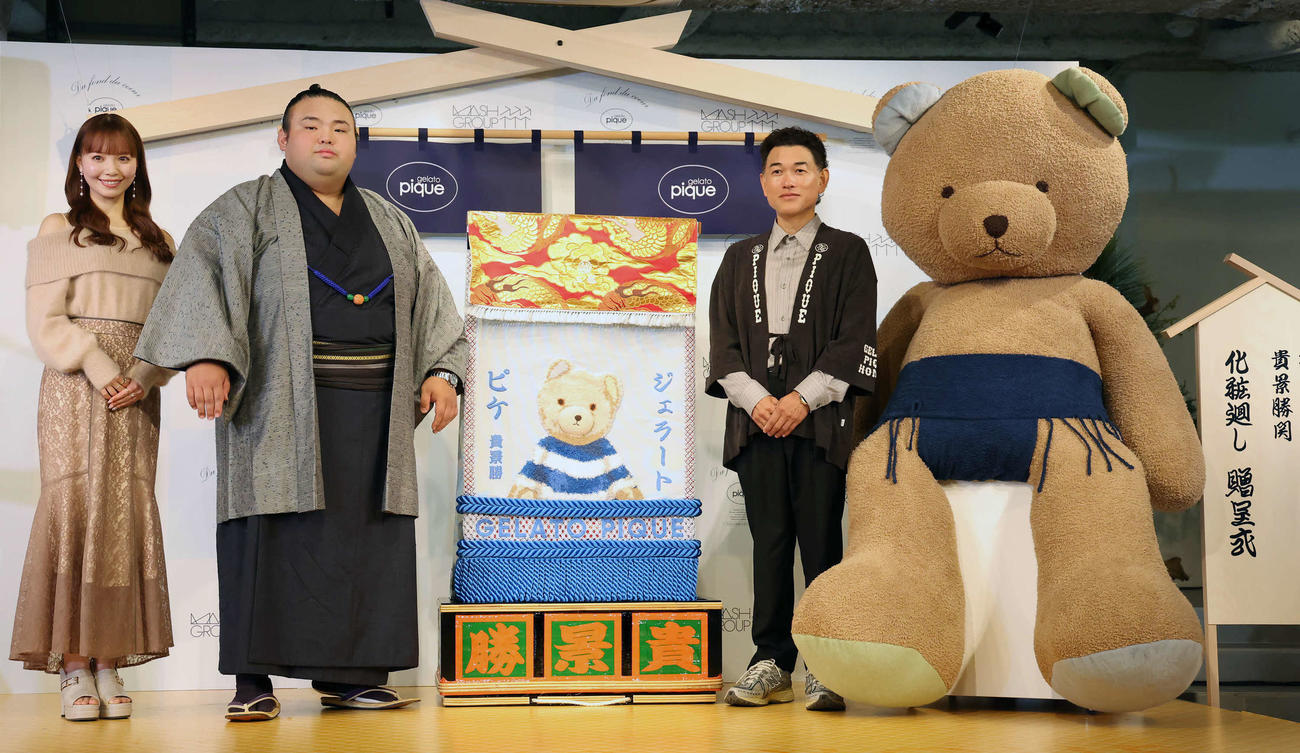 贈呈された化粧まわしと写真に納まる、左からスー女の山根千佳、貴景勝関、マッシュホールディングスの近藤広幸社長（撮影・丹羽敏通）