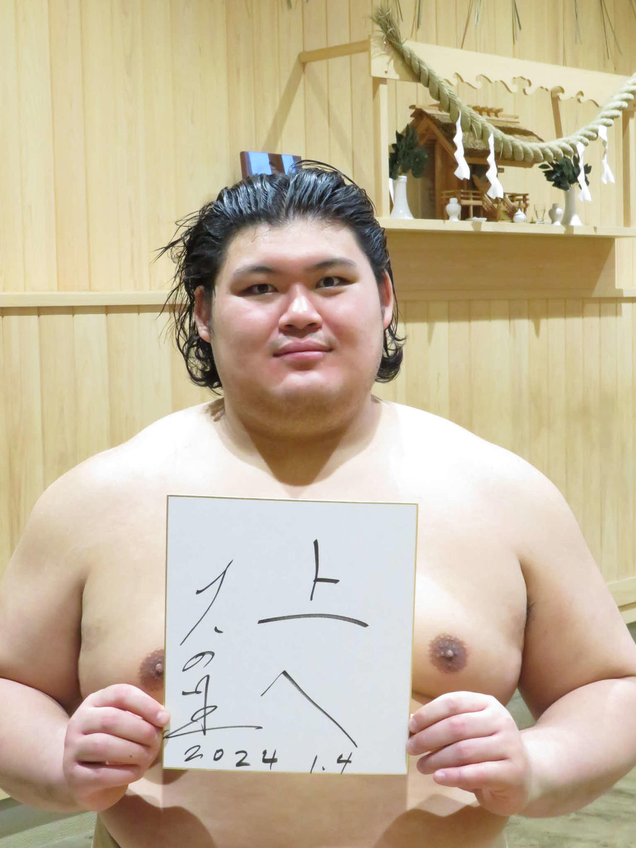 今年の目標として色紙に「上へ」と記し、表情を引き締めた大の里
