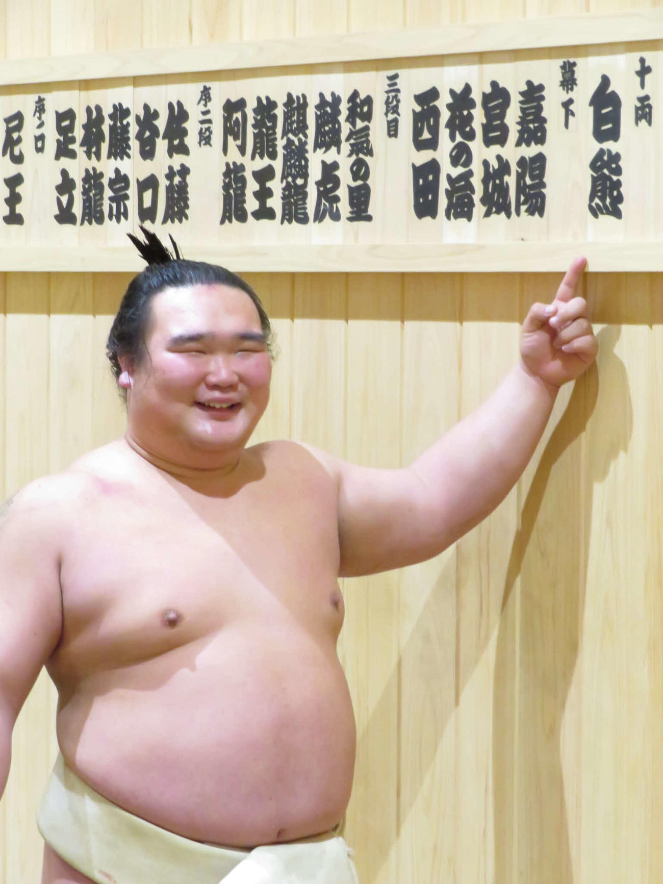高橋から改名し、笑顔で新たなしこ名の木札を指さす白熊