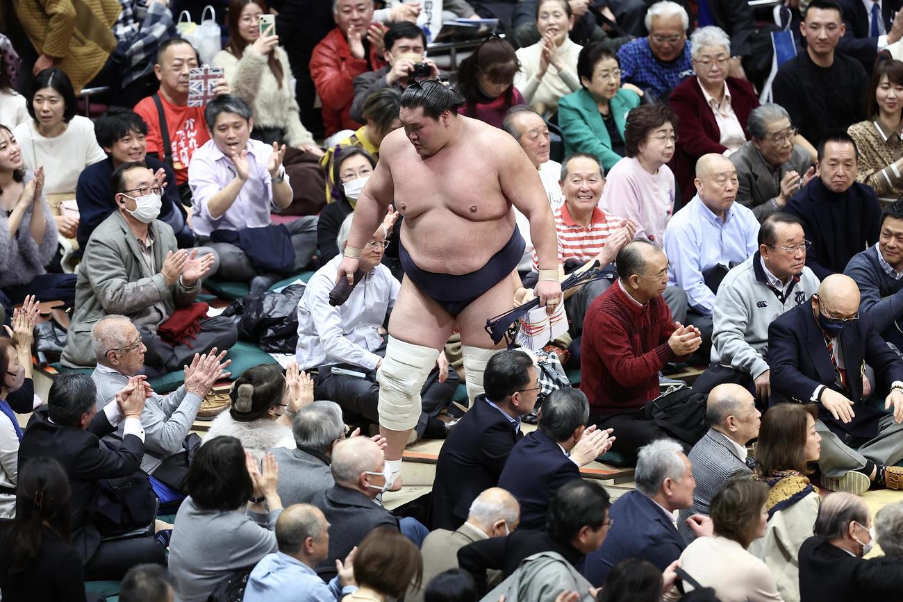 宇良を押し出しで破り、懸賞金の束を手に花道から引き揚げる照ノ富士（中央）（撮影・河田真司）