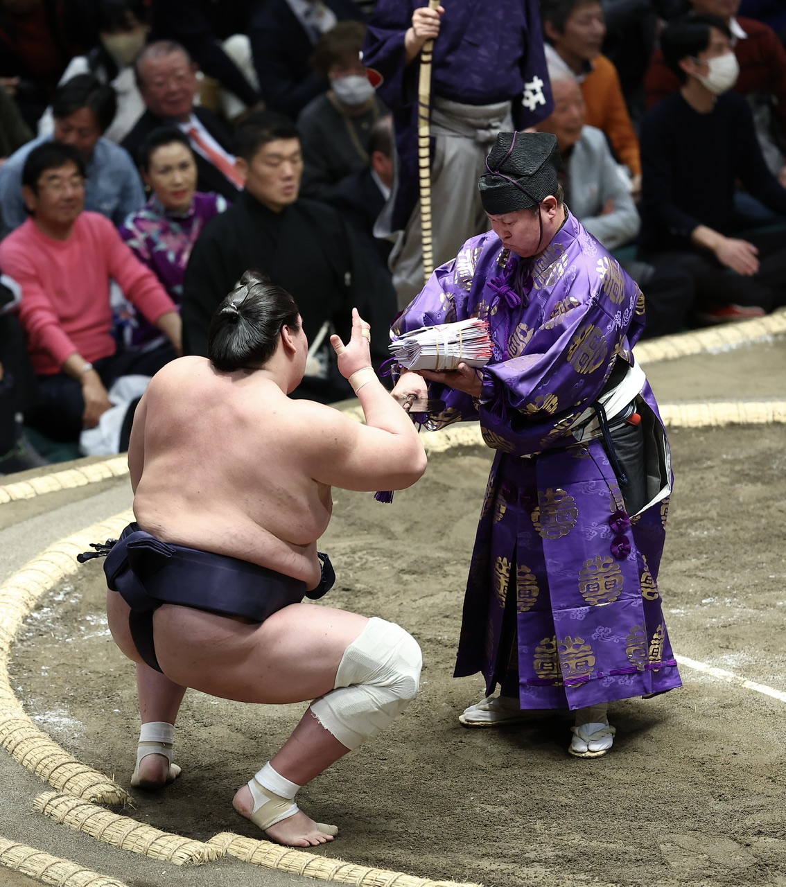 照ノ富士（左）に懸賞金の束を渡す行司の木村庄之助（撮影・河田真司）