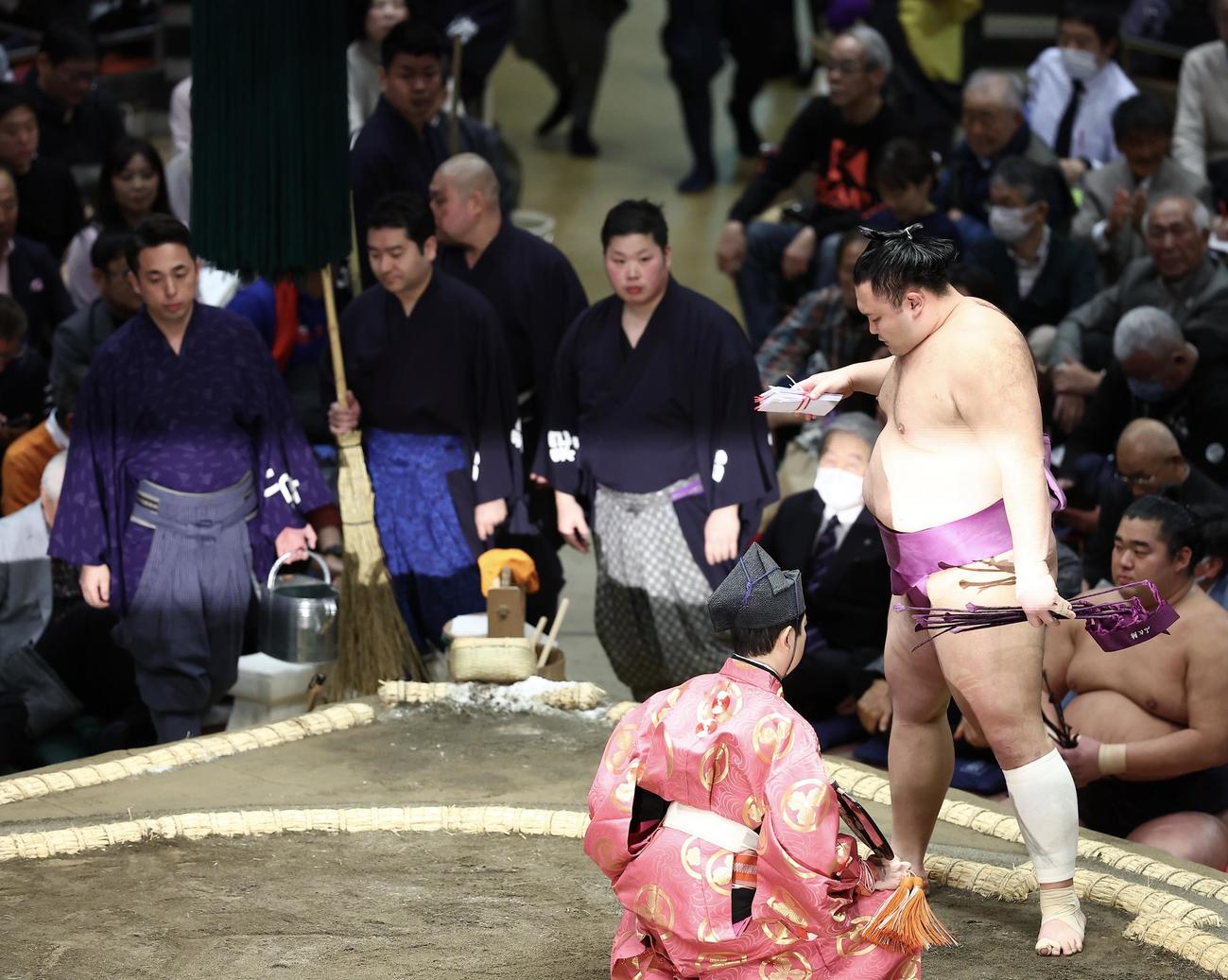 一山本を押し出しで破り、懸賞金の束を手にする朝乃山（撮影・河田真司）