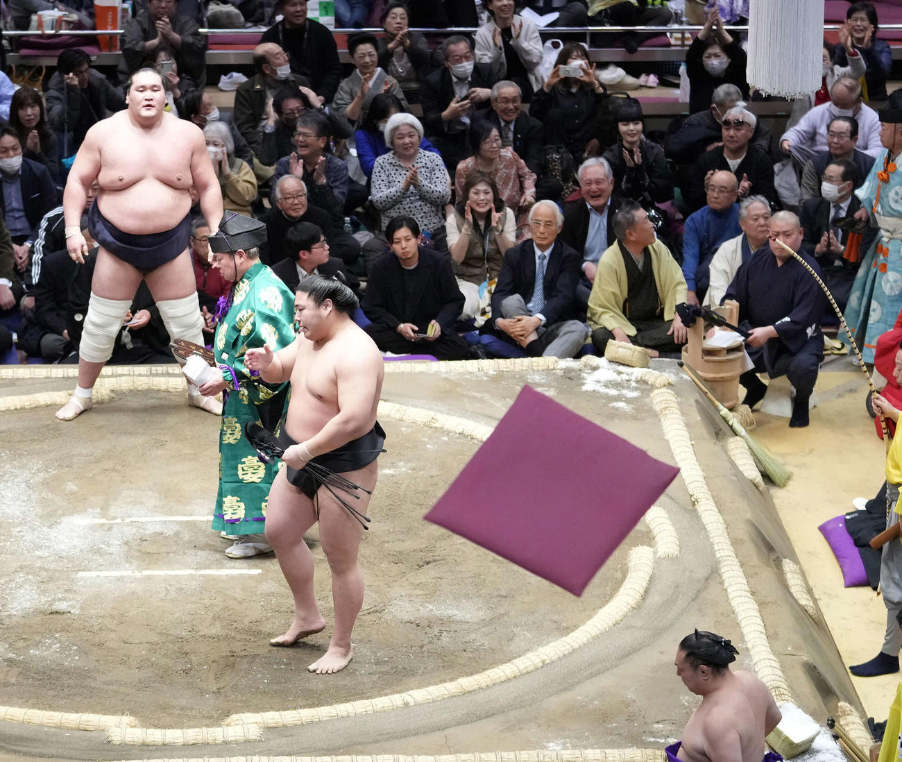 照ノ富士（左奥）は若元春に寄り切りで破れ場内に座布団が舞う（撮影・小沢裕）