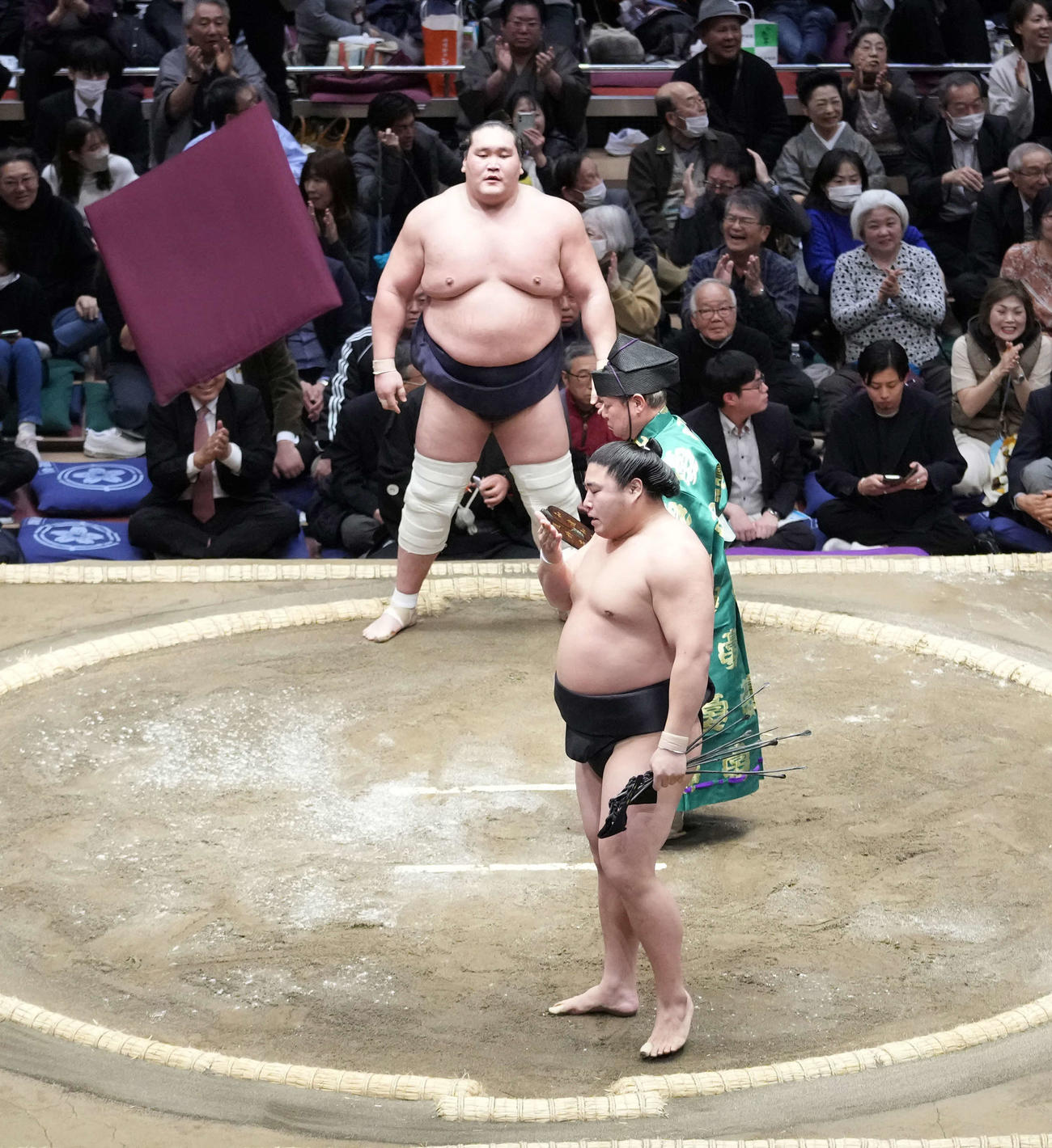 照ノ富士（奥）は若元春に寄り切りで敗れ、場内に座布団が舞う（撮影・小沢裕）