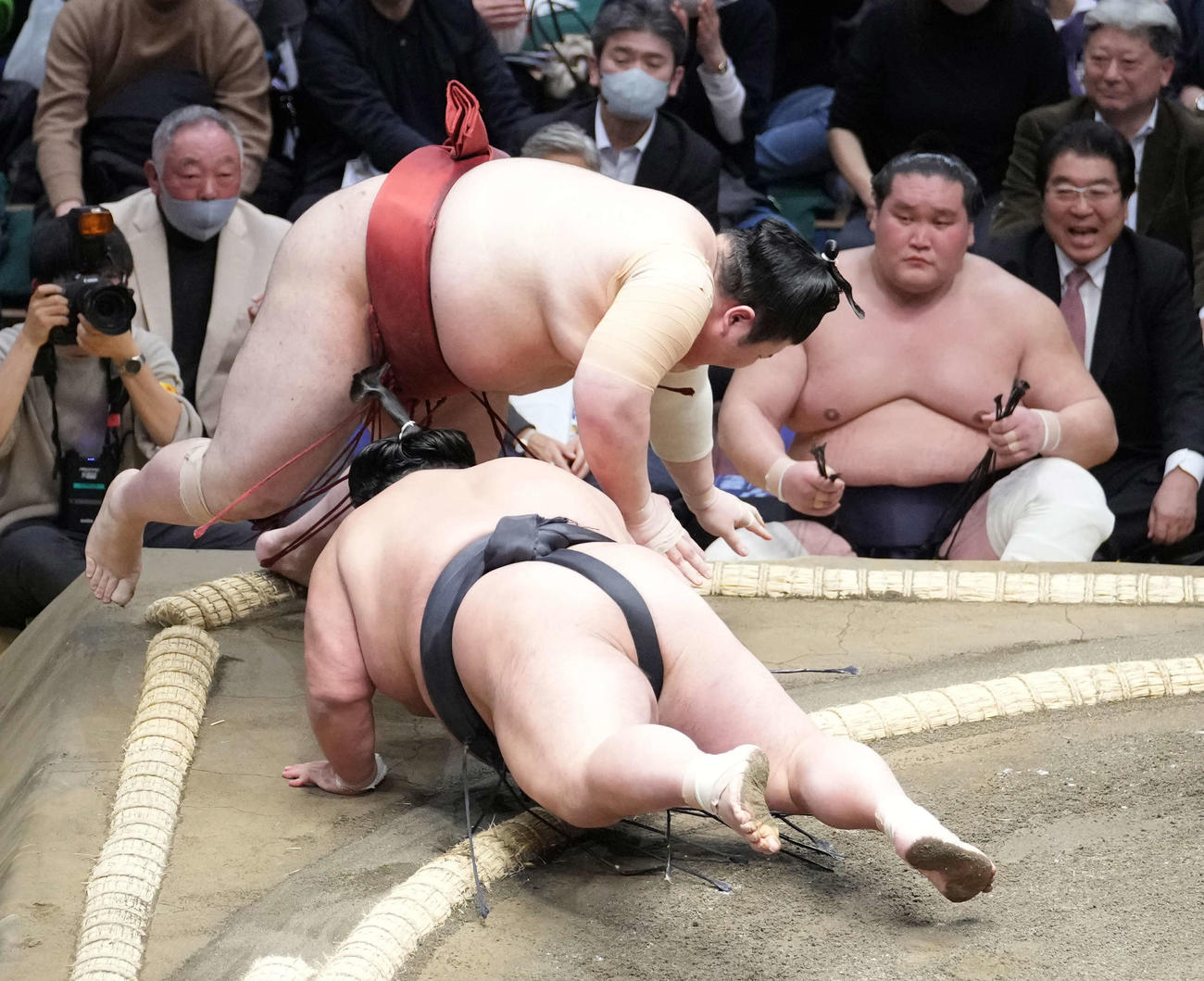貴景勝（手前）は熱海富士を寄り切りで破る。右は土俵控えの照ノ富士（撮影・小沢裕）